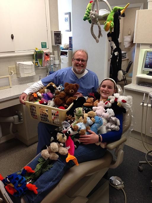 Junior Meghan Swoboda, right, poses alongside dentist Paul Moore with the stuffed animals she collected.