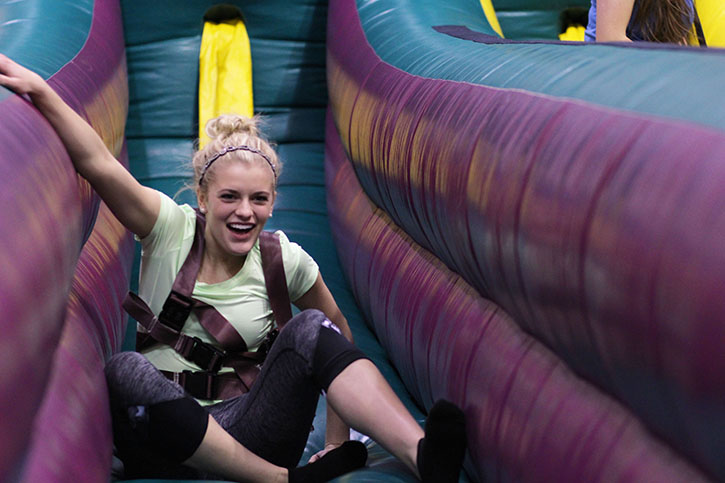 During the spring celebration hosted by Viking Way, junior Karlie Kinsey slides and falls in the inflatable, Feb. 23. 
