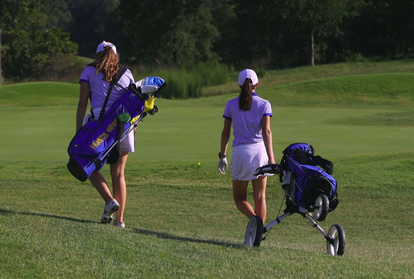 Sept.+8%2C+seniors+Cristen+Voges+and+Jess+Jostes+tote+their+bags+during+the+match+against+Timberland.+