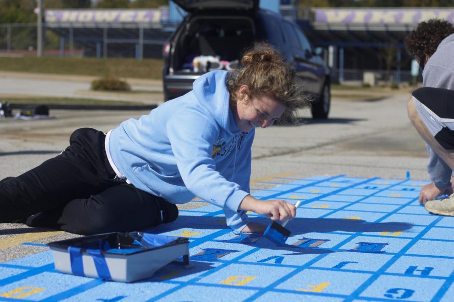 Senior Lilli Machado paints her parking spot.